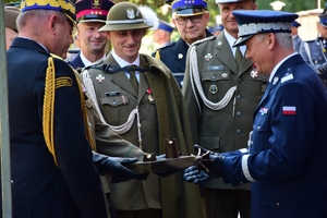 Przedstawiciele służb mundurowych (wojska, straży granicznej, straży pożarnej, służby więziennej) wręczają Komendantowi Wojewódzkiemu Policji w Rzeszowie (po prawej) generalski buzdygan.