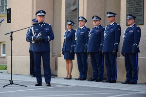 Komendant Wojewódzki Policji w Rzeszowie nadinsp. Dariusz Matusiak po lewej, przy mikrofonie. W tle policjanci.
