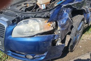Zdjęcie kolorowe wykonane w porze dziennej przedstawia samochód osobowy marki ford fokus koloru granatowego z uszkodzonym przodem pojazdu . Samochód po kolizji drogowej