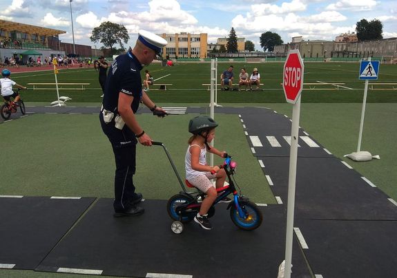 Policjant z dziewczynką na rowerze na ternie miasteczka rowerowego