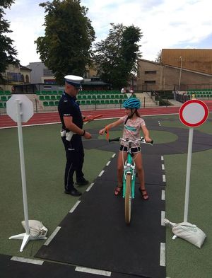 Miasteczko rowerowe. Policjant i dziewczynka na rowerze