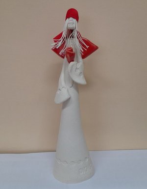 Zdjęcie kolorowe przedstawia statuetkę &quot;Anioł dawcy szpiku&quot; w kolorze białym z czerwona czapeczka oraz czerwonymi skrzydłami