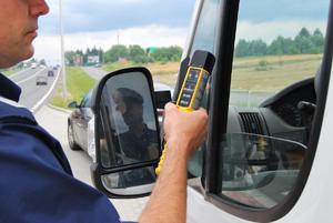 policjant trzymający urządzenie do sprawdzania stanu trzeźwości