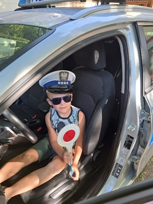 Dziecko siedzi w radiowozie policyjnym