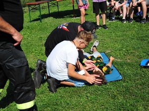 na zdjęciu chłopiec ze strażakiem trenuje udzielanie pierwszej pomocy