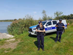 Zdjęcie kolorowe wykonane w porze dziennej przedstawia policjantów z Komisariatu Policji w Medyce którzy kontrolują  tz. „dzikie kąpieliska”