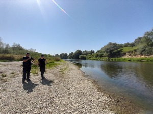 Zdjęcie kolorowe wykonane w porze dziennej przedstawia policjantów z Komisariatu Policji w Medyce którzy kontrolują  tz. „dzikie kąpieliska”