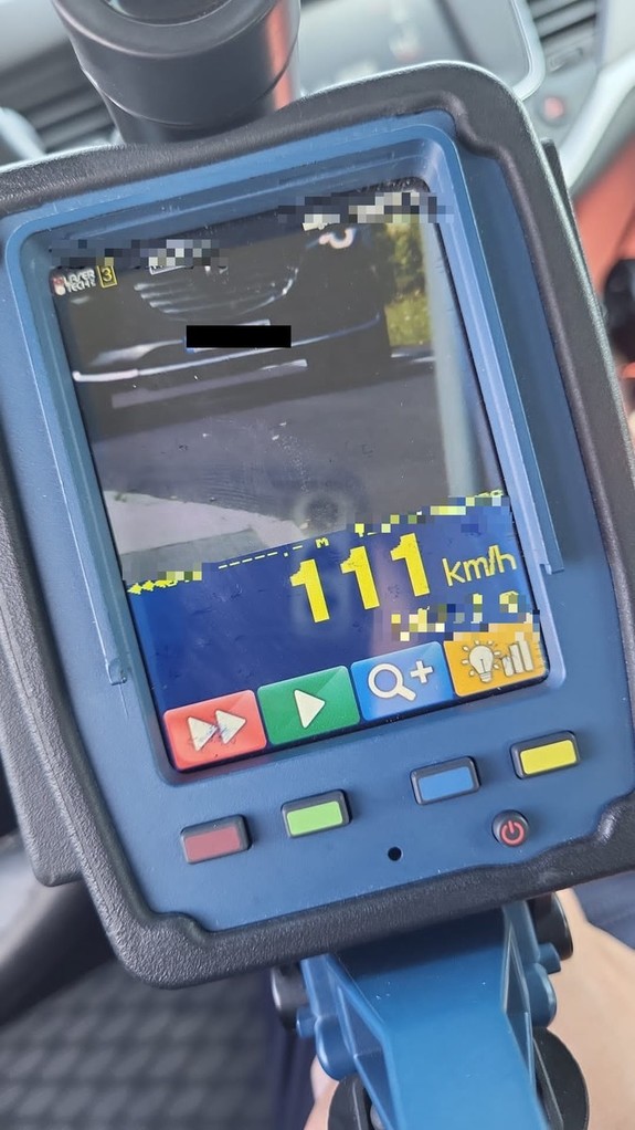 Miernik prędkości koloru niebieskiego pokazujący pomiar prędkości, na ekranie widoczny samochód marki mazda.