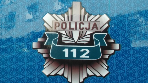 Odznaka policyjna na niebieskim tle z nr 112