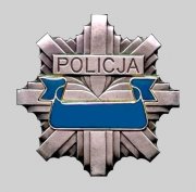 Zdjęcie przedstawia gwiazdę policyjną w kolorze srebrnym w środku odznaki znajduje się wygrawerowany napis POLICJA, pod napisem widoczna jest wstęga w kolorze niebieskim