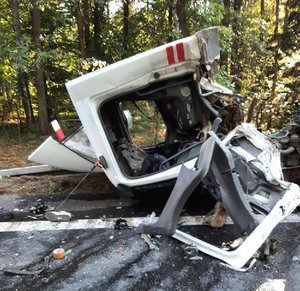 Uszkodzony w wyniku zdarzenia samochód, który brał udział w wypadku, pora dzienna w tle drzewa