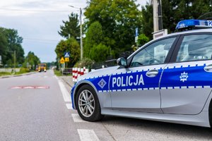 Radiowóz, w tle widoczne przejście dla pieszych i oznakowanie w rejonie szkoły