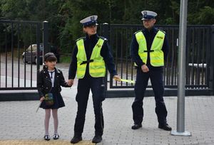 Policjantka uczy dziewczynkę jak należy przechodzić przez przejście dla pieszych