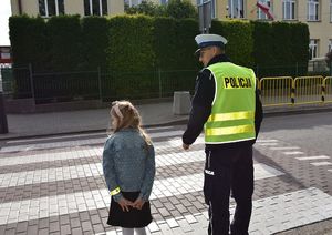 Policjant tłumaczy dziewczynce, jak prawidłowo należy przechodzić przez przejście dla pieszych