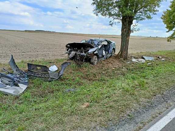 Samochód rozbity po wypadku stojący przy drzewie w któro wcześniej uderzył