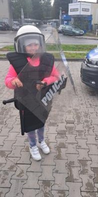Dziecko ubrane w sprzęt będący na wyposażeniu policjantów