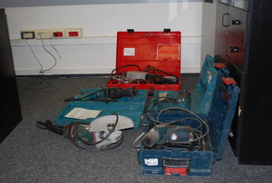 Na zdjęciu leżące na podłodze trzy walizki z elektrosprzętem w kolorze czerwonym,   niebieskim i zielonym.