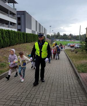 Policjant prowadzi dziecko za rękę