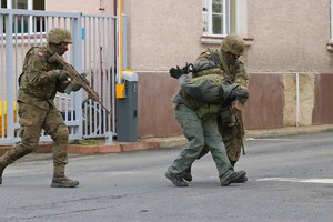 Ćwiczenie PERUN 2022. na zdjęciu grupa policjantów i żołnierzy, prowadzą zatrzymanego