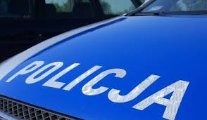 Zdjęcie kolorowe -przedstawia napis &quot;POLICJA&quot;w kolorze białym na niebieskim tle maski samochodu oznakowanego