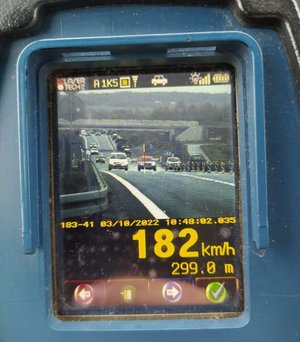 Na zdjęciu ekran laserowego miernika prędkości, na którym widać trasę S19 i jadące w obu kierunkach samochody. Samochód, którego kierowca przekroczył prędkość zaznaczmy jest czerwonym krzyżykiem. Pod zdjęciem żółtymi cyframi wyświetla się data i godzina wykroczenia oraz wartość przekroczonej prędkości 182 km/h