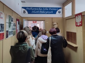 Młodzież oraz jej opiekunowie wchodzący korytarzem do pomieszczeń Podkarpackiej Izby Pamięci Służb Policyjnych