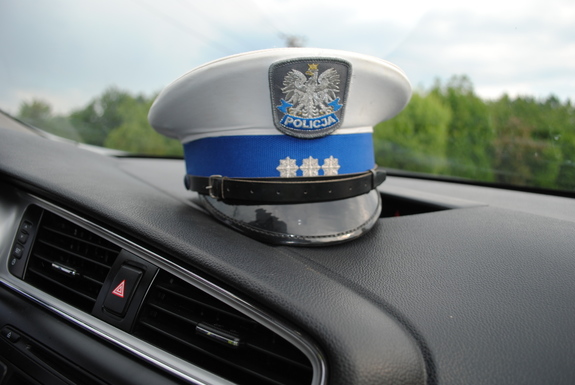 Zdjęcie przedstawia czapkę policjanta ruchu drogowego która umieszczona jest na podszybiu samochodu
