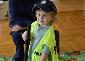 Dziewczynka ubrana w elementy policyjnego umundurowania.