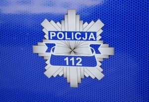 Odznaka policyjna na której widnieje numer 112