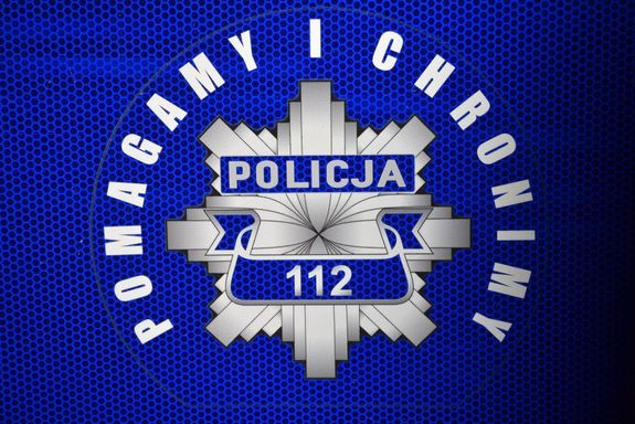Gwiazda policyjna z napisem Policja i nr 112. Wokół niej znajduje się napis o treści Pomagamy i chronimy.