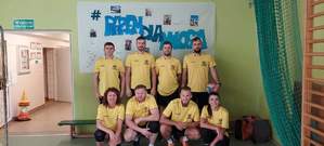 Zdjęcie kolorowe przedstawia drużynę siatkarzy , którzy brali udział w charytatywnym półfinale pod nazwą &quot;Razem dla Miłosza&quot; Na zdjęciu znajduje się 8 osób ubranych w żółte koszulki i czarne spodenki