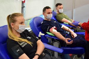policjanci i inni funkcjonariusze siedzą na fotelach i oddają krew