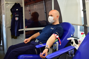 policjant siedzący na fotelu oddający krew