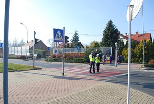 Na zdjęci dwoje umundurowanych policjantów ruchu drogowego w żółtych kamizelkach odblaskowych kieruje ruchem na ul. Żołnierzy I Armii Wojska Polskiego.