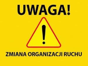 żółta tablica ze znakiem z wykrzyknikiem i czarnym napisem - uwaga zmiana organizacji ruchu