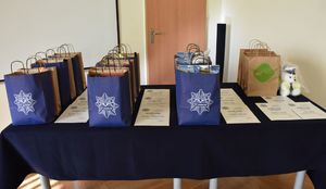 Nagrody oraz dyplomy dla laureatów konkursu Bezpieczne Wakacje, poukładane na stoliku