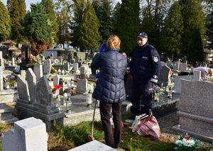 policjant na cmentarzu rozmawia z kobietą