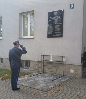Komendant Grazda oddaje hołd przed tablicą zamieszczoną na budynku KPP Mielec