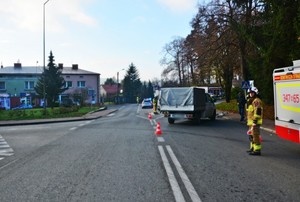 Widok skrzyżowania i stojący wóz strażacki, dostawczy volkswagen i na drugim planie policyjny radiowóz podczas działań na miejscu wypadku drogowego