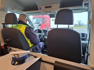 policjant podczas kontroli drogowej, funkcjonariusz siedzi za kierownicą nowego radiowozu