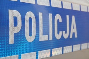 biały napis policja na niebieskim pasie bocznym radiowozu