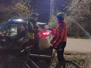 Policjanci dają odblask kierującej rowerem