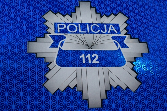 Odznaka policyjna z wpisanym numerem 112