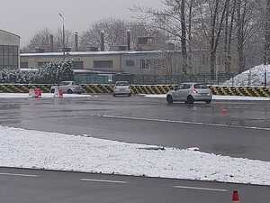 Szkolenie z techniki jazdy na torze. Na zdjęciu samochód na torze, sala wykładowa i uczestnicy