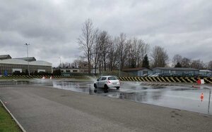 Szkolenie z techniki jazdy na torze. Na zdjęciu samochód na torze, sala wykładowa i uczestnicy