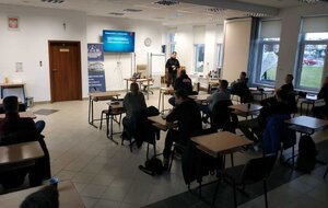 Szkolenie z techniki jazdy na torze. Na zdjęciu samochód na torze, sala wykładowa i uczestnicy