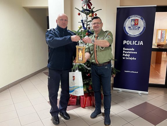 zdjęcie przedstawia Komendanta Powiatowego Policji w Leżajsku wraz z delegatem z ZHP Hufiec Leżajsk podczas przekazywania betlejemskiego światełka.