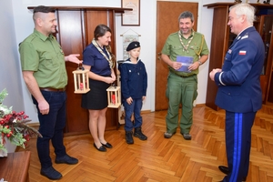 Delegacja harcerska przekazuje lampion ze Światełkiem Betlejemskim Komendantowi Wojewódzkiemu Policji. Zdjęcie wykonane w gabinecie Komendanta.