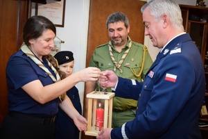 Delegacja harcerska przekazuje lampion ze Światełkiem Betlejemskim Komendantowi Wojewódzkiemu Policji. Zdjęcie wykonane w gabinecie Komendanta.