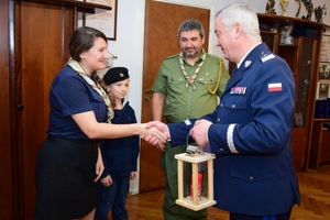 Delegacja harcerska przekazuje lampion ze Światełkiem Betlejemskim Komendantowi Wojewódzkiemu Policji. Zdjęcie wykonane w gabinecie Komendanta.